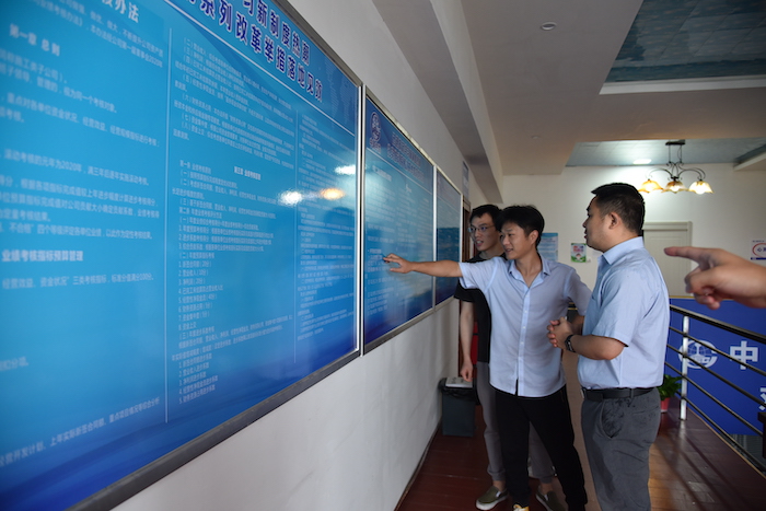 1595819793814075.jpg 图2:员工在制度展板前交流学习.JPG